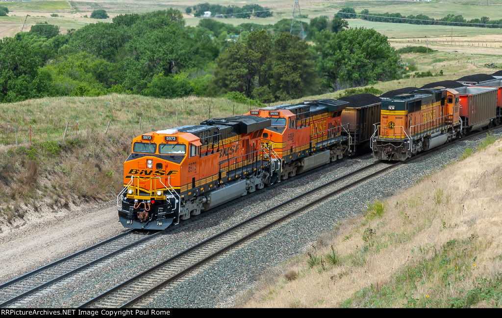BNSF 5973 and 5698 are eastbound with a loaded coal train passing the westbound DPU unit BNSF 9868 on a returning empty hopper train on Crawford Hill